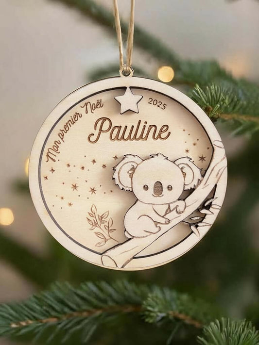 Boule de Noël en bois personnalisée motif Koala, suspendue dans un sapin décoré.