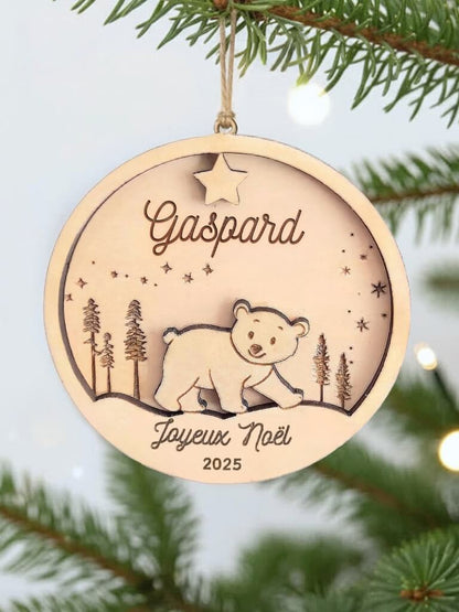 Boule de Noël en bois personnalisée motif d’Ours, suspendue dans un sapin décoré.