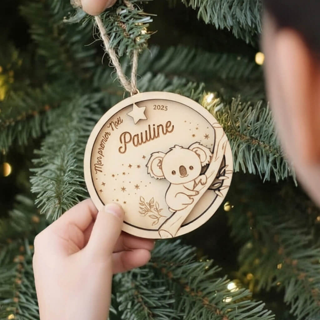 Ornement de Noël en bois motif Koala, suspendu et vu en angle dans le sapin.