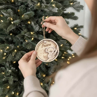 Suspension de Noël en bois motif Koala, accrochée au sapin par une main.