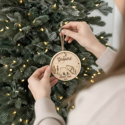 Suspension de Noël en bois motif d’Ours, accrochée au sapin par une main.
